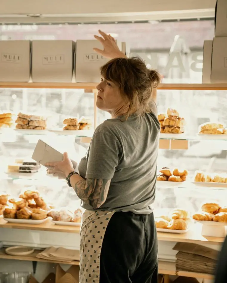 Commerçante arrangeant sa vitrine de viennoiseries